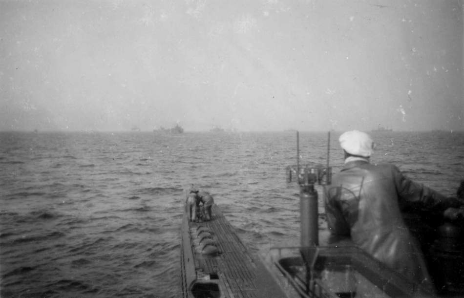 A U-boat stalking a convoy, which can be seen scattered ahead.